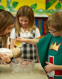 Students performing a baptism on doll